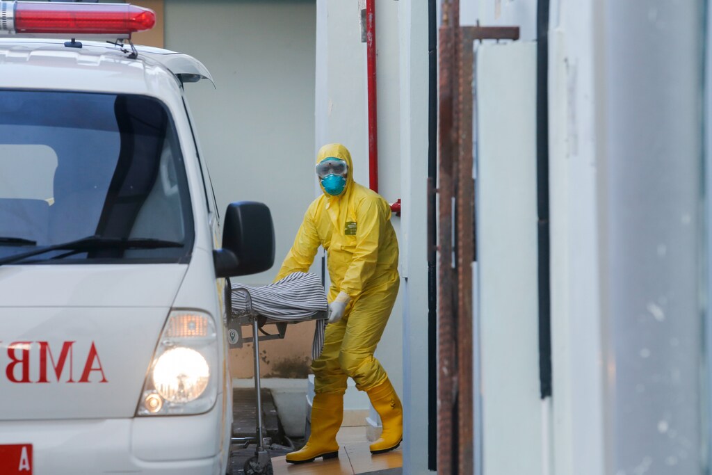 A medical worker wearing protective suits pulls a stretcher from an ambulance to the isolation room for patients affected coronavirus disease (COVID-19) at Sanglah Hospital in Denpasar, Bali, Indonesia, March 11, 2020. REUTERS/Johannes P. Christo - RC2OHF9YLHLX