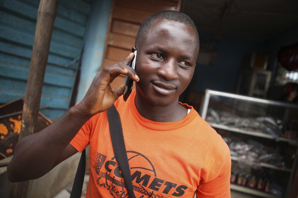 A man makes a call on a mobile phone in Sierra Leone's capital Freetown December 13, 2012. While mobile phone usage has exploded across Africa over the last decade, transforming daily life and commerce for millions, it's a revolution that has left behind perhaps two thirds of its people. Poor or no reception outside the towns helps explain why the continent's mobile penetration, in terms of the percentage of the population using the service, is far lower than previously thought, and the cost of providing that service to impoverished, sparsely populated areas remains prohibitive. Picture taken December 13, 2012. REUTERS/Simon Akam (SIERRA LEONE - Tags: BUSINESS TELECOMS SOCIETY) - GM1E91V1KRN01