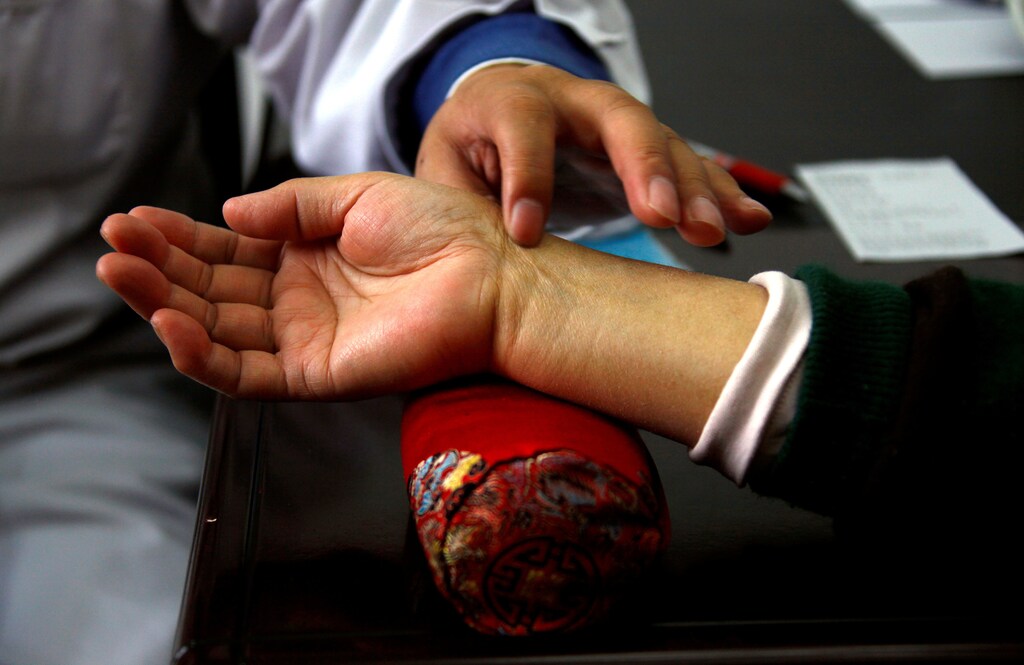 A diabetes patient has her pulse checked by a diabetes specialist doctor during a medical check-up at a hospital in Beijing, China March 19, 2012. REUTERS/David Gray/File Photo - RTSH45Q