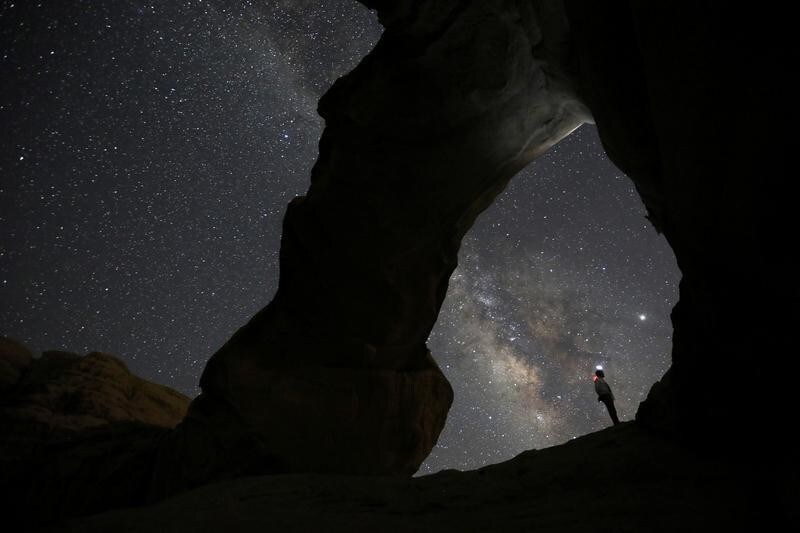 A man watches the stars seen on the sky of Al-Kharza area of Wadi Rum in the south of Amman, Jordan, July 27, 2019. Picture taken July 27, 2019. REUTERS/Muhammad Hamed TPX IMAGES OF THE DAY - RC157F415170