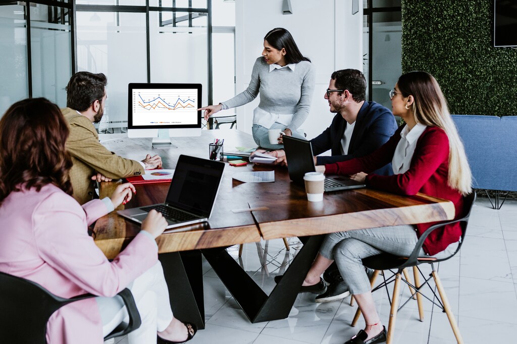 Gender equality: a meeting being given by a woman to several people around a table.
