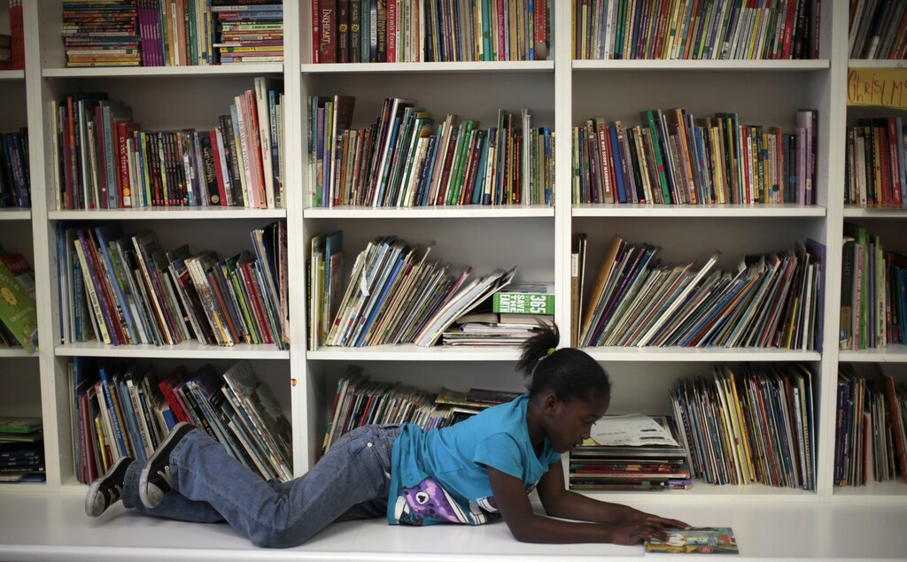 Iana Williams, 8, who is homeless, reads a book at a School on Wheels' after-school program in Los Angeles, February 9, 2012. School on Wheels provides tutoring and educational mentoring to homeless children. A recent report by the National Alliance to End Homelessness found that California's population of homeless families increased by five percent between 2009 and 2011. It is estimated that there are over 300,000 homeless children in California. REUTERS/Lucy Nicholson (UNITED STATES - Tags: EDUCATION SOCIETY) - RTR2XKVW