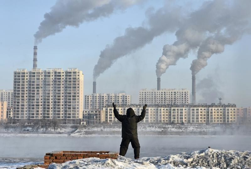 An elderly man exercises in the morning as he faces chimneys emitting smoke behind buildings across the Songhua river in Jilin, Jilin province, February 24, 2013. China's new rulers will focus on consumer-led growth to narrow the gap between rich and poor while taking steps to curb pollution and graft, the government said on Tuesday, tackling the main triggers for social unrest in the giant nation. Picture taken February 24, 2013. REUTERS/Stringer (CHINA - Tags: ENVIRONMENT BUSINESS POLITICS) CHINA OUT. NO COMMERCIAL OR EDITORIAL SALES IN CHINA - GM1E9351DC501