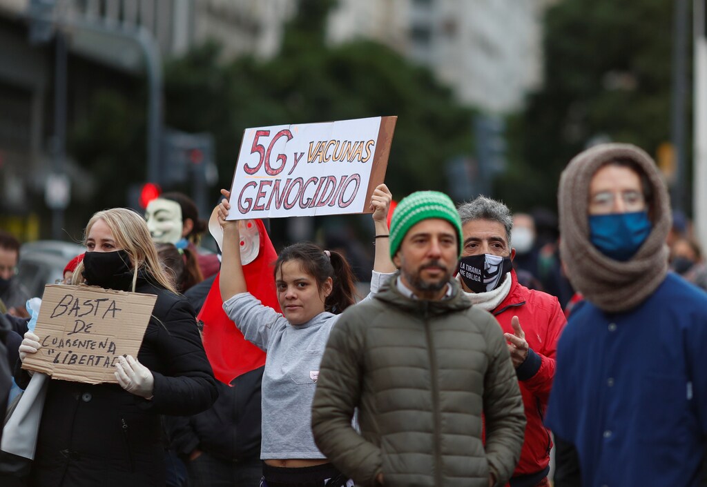 Anti-quarantine demonstrators holds a placard that reads "5G and vaccines genocide", during a protest against the quarantine measures in the city of Buenos Aires, amid the coronavirus disease (COVID-19) outbreak, at the Buenos Aires obelisk, Argentina May 30, 2020. REUTERS/Agustin Marcarian - RC29ZG9UC60N