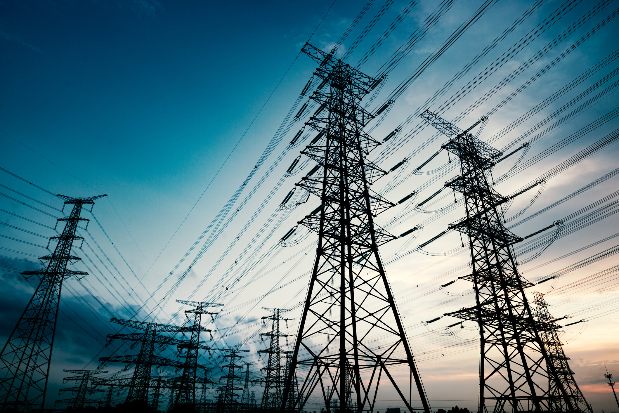 Power lines for carrying electricity against a coloured sky. Realism is key in the global energy transition, as we seek to balance sustainability with growth — particularly in the developing world. is key in the global energy transition, as we seek to balance sustainability with growth — particularly in the developing world.