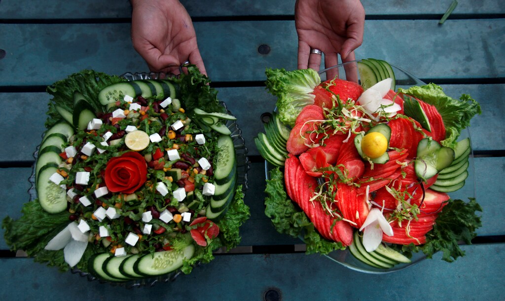 A waiter presents two types of salad served by Habibi restaurant in Peshawar, Pakistan January 31, 2018. REUTERS/Fayaz Aziz - RC11A36ACAB0