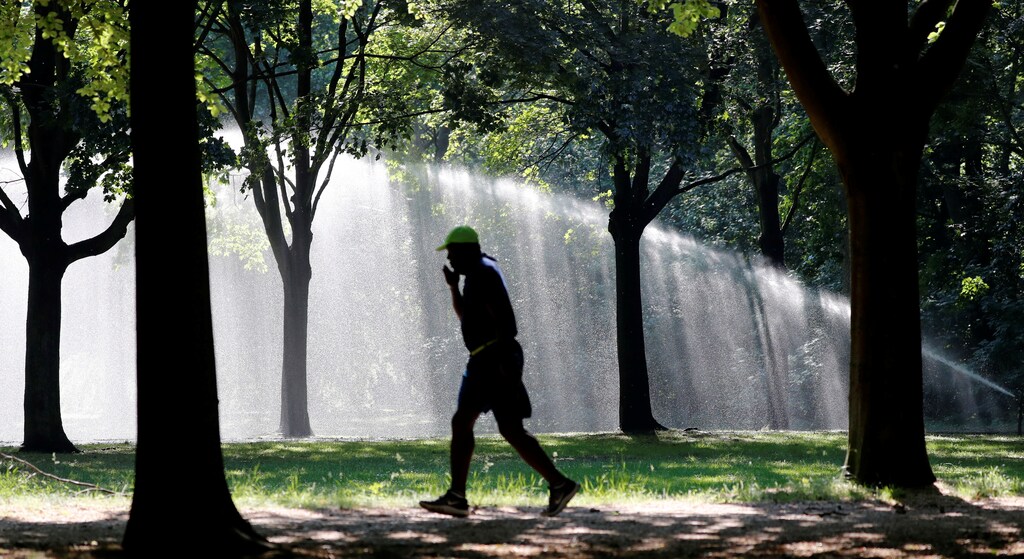 A man jogs across Tiergarten park in Berlin, Germany.