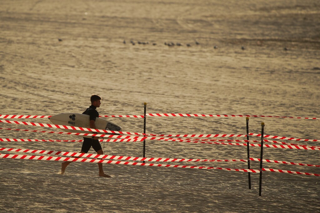 A man walks to the sea as Bondi Beach reopens to surfers and swimmers after it was closed to curb the spread of the coronavirus disease (COVID-19), with strict social distancing measures remaining in place, in Sydney, Australia, April 28, 2020. REUTERS/Loren Elliott - RC2ADG9UVQ8D