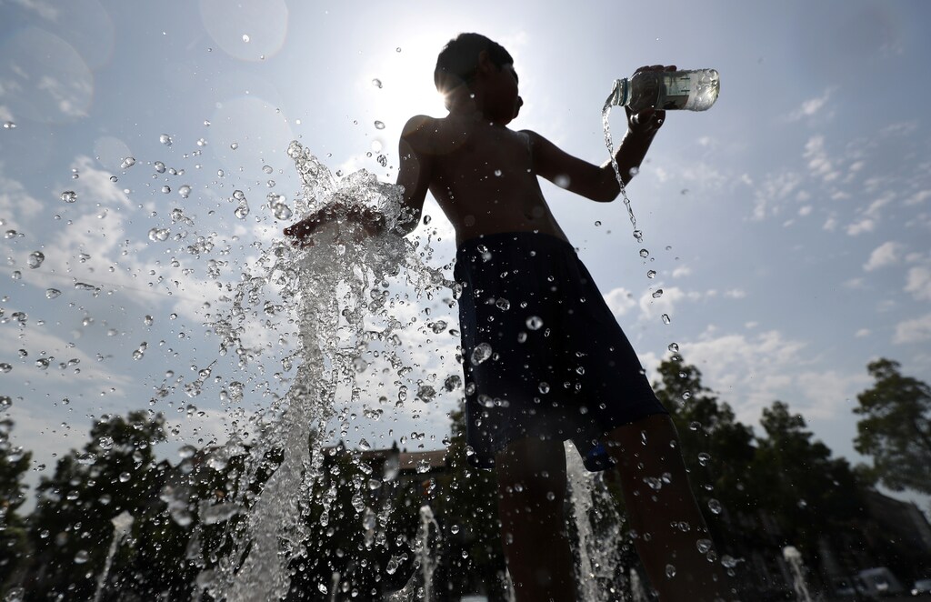 A boy plays with water in a fountain on a hot summer day in Brussels, Belgium, July 25, 2019. REUTERS/Yves Herman - RC116BE56CA0