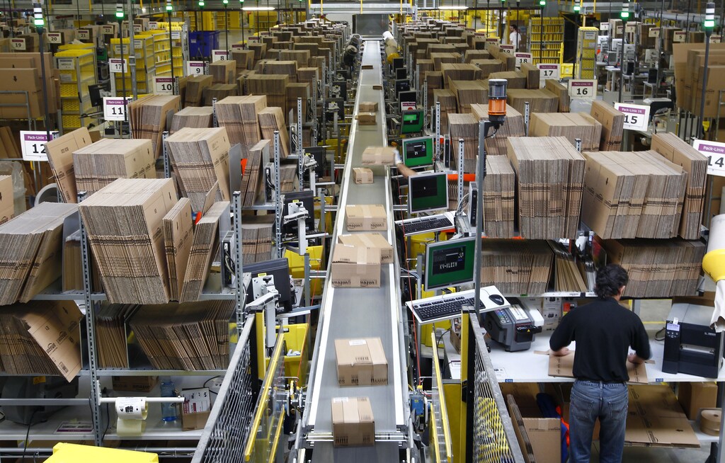Workers pack boxes at Amazon's logistics centre in Graben near Augsburg December 16, 2013. Workers at Amazon.com's German operations were set to go on strike on Monday, in the middle of the crucial Christmas holiday season, in a dispute over pay that has been raging for months. The Verdi union said workers would strike in Amazon's logistic centres in Bad Hersfeld and Leipzig and, for the first time, in Graben. REUTERS/Michaela Rehle (GERMANY - Tags: BUSINESS EMPLOYMENT) - RTX16KXH