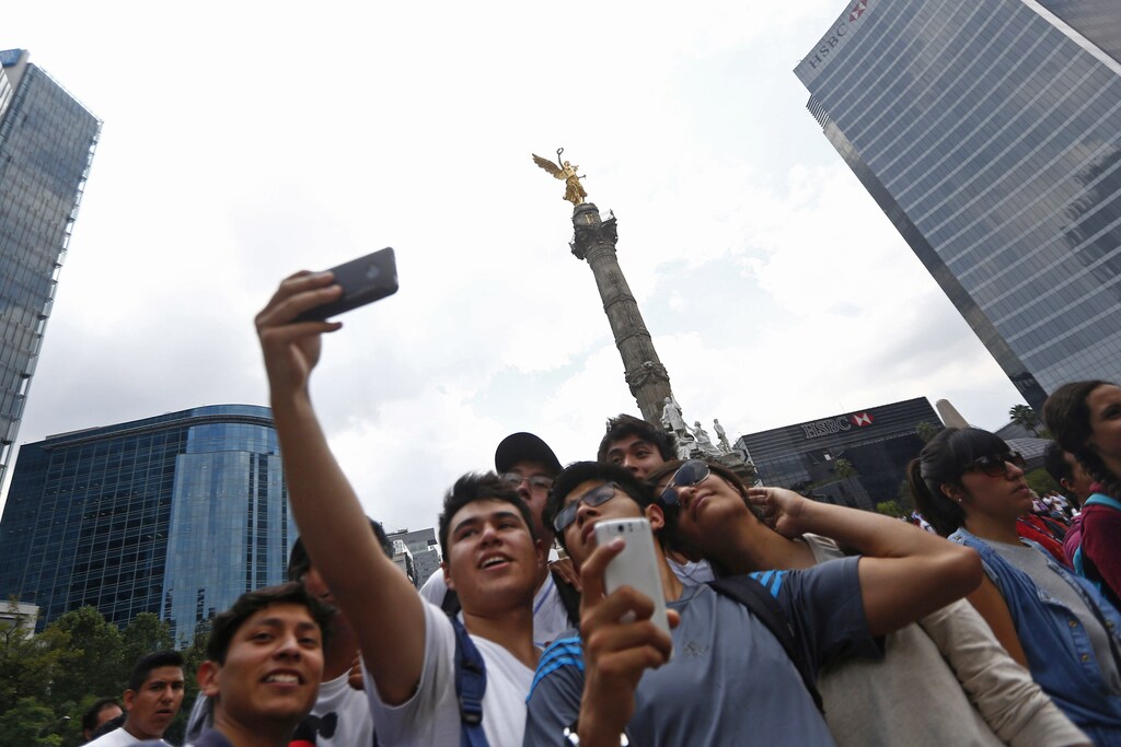 Students from the National Polytechnic Institute (IPN) take a selfie during a demonstration at Angel de la Independencia monument in Mexico City.