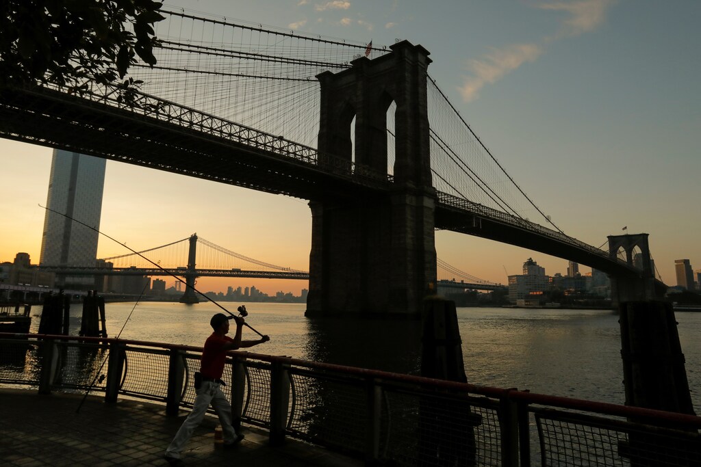 A man casts his line out as he goes fishing under the Brooklyn Bridge at sunrise as a heatwave continues to affect the region in New York, U.S., July 21, 2019. REUTERS/Andrew Kelly TPX IMAGES OF THE DAY - RC159D8AFC50