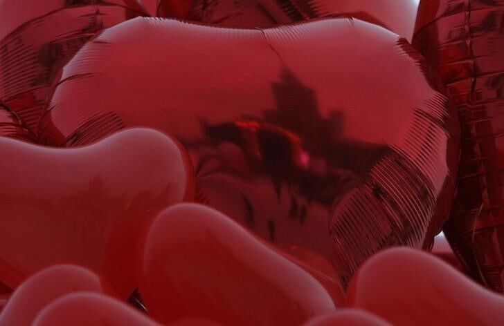 The Palace of Culture is reflected in heart-shape balloons that are being sold during an annual charity event organized by Christmas Charity Foundation (Wielka Orkiestra Swiatecznej Pomocy) in Warsaw January 13, 2013. Every year, people across the country collect money for the charity "Great Orchestra of Christmas", which buys equipment for children's hospitals. REUTERS/Kacper Pempel (POLAND - Tags: SOCIETY TRAVEL)