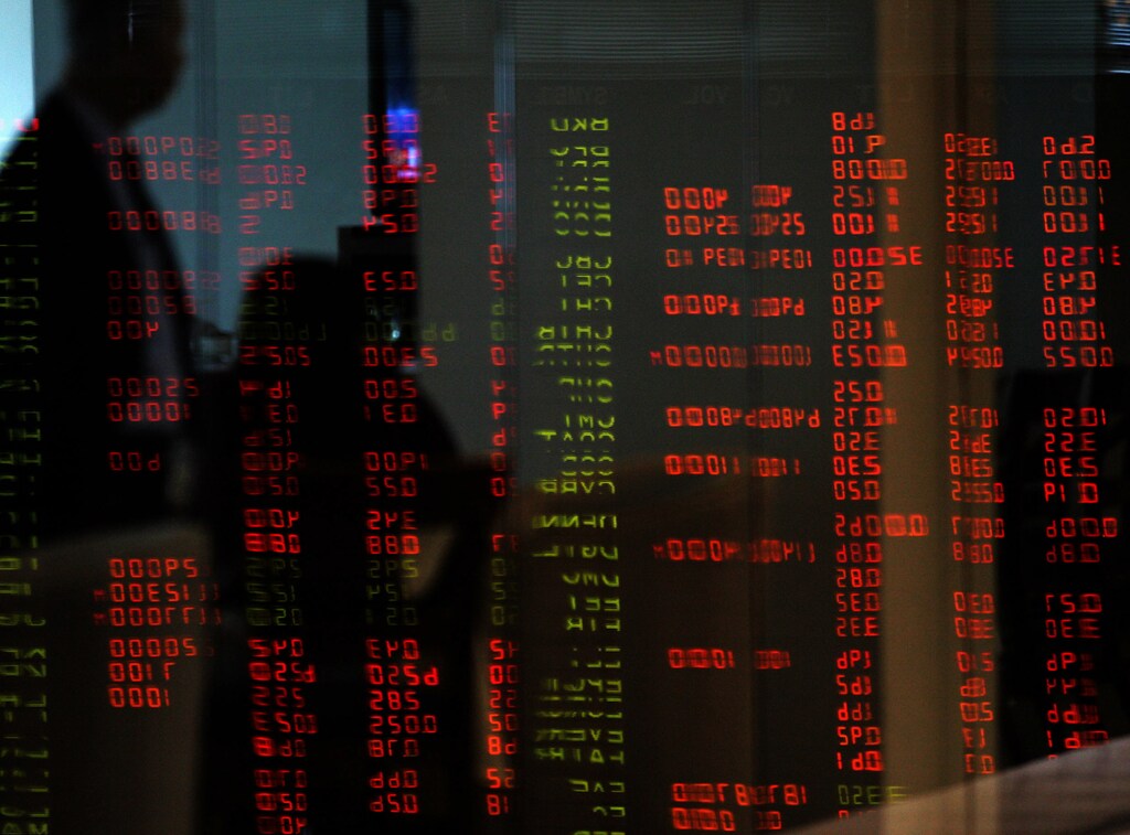A Filipino trader stands against the reflections of trading figures inside the Philippine Stock Exchange in Makati's financial district at Manila February 27, 2006. REUTERS/Romeo Ranoco - RP3DSFDDHDAA