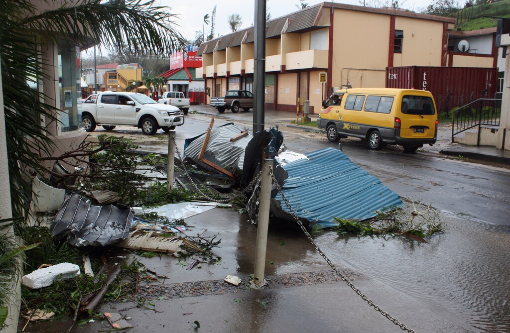 Debris lies in a street near damaged buildings in Port Vila, the capital city of the Pacific island nation of Vanuatu March 14, 2015. Winds of up to 250 kilometers an hour (155 mph) ripped metal roofs off houses and downed trees in Vanuatu on Saturday, as relief agencies braced for a major rescue operation and unconfirmed reports said dozens had already died. Witnesses described sea surges of up to eight meters (yards) and flooding throughout the capital Port Vila after the category 5 cyclone named Pam hit the country late on Friday. Picture taken March 14, 2015. REUTERS/Kris Paras (VANUATU - Tags: DISASTER ENVIRONMENT) - GM1EB3F0T0E01