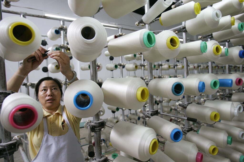 An employee works at a textile factory in Shidian county, Yunnan province August 20, 2009. China's gross domestic product will grow about 8.5 percent in the third quarter from a year earlier, picking up from the second quarter's 7.9 percent pace, a government think-tank said on Friday. Picture taken August 20, 2009. REUTERS/Stringer (CHINA BUSINESS) CHINA OUT. NO COMMERCIAL OR EDITORIAL SALES IN CHINA - GM1E58L0ZFW01