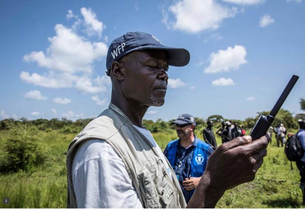 A World Food Programme employee uses a satellite phone to coordinate a U.N's World Food Programme (WFP) food aid air drop near the town of Katdalok, in Jonglei State of South Sudan July 30, 2018.