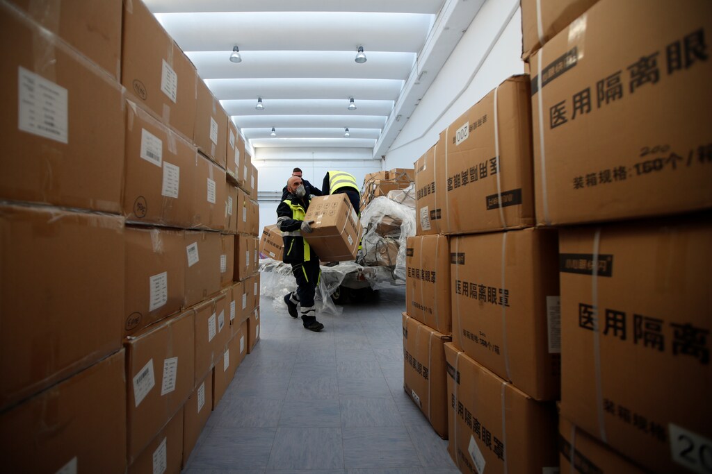 Workers pile up a shipment containing supplies of personal protective equipment (PPE) at Bari airport after arriving from Guangzhou, China, to help the southern Italian region of Puglia combat a spread of the coronavirus disease (COVID-19), in Bari, Italy, April 7, 2020.