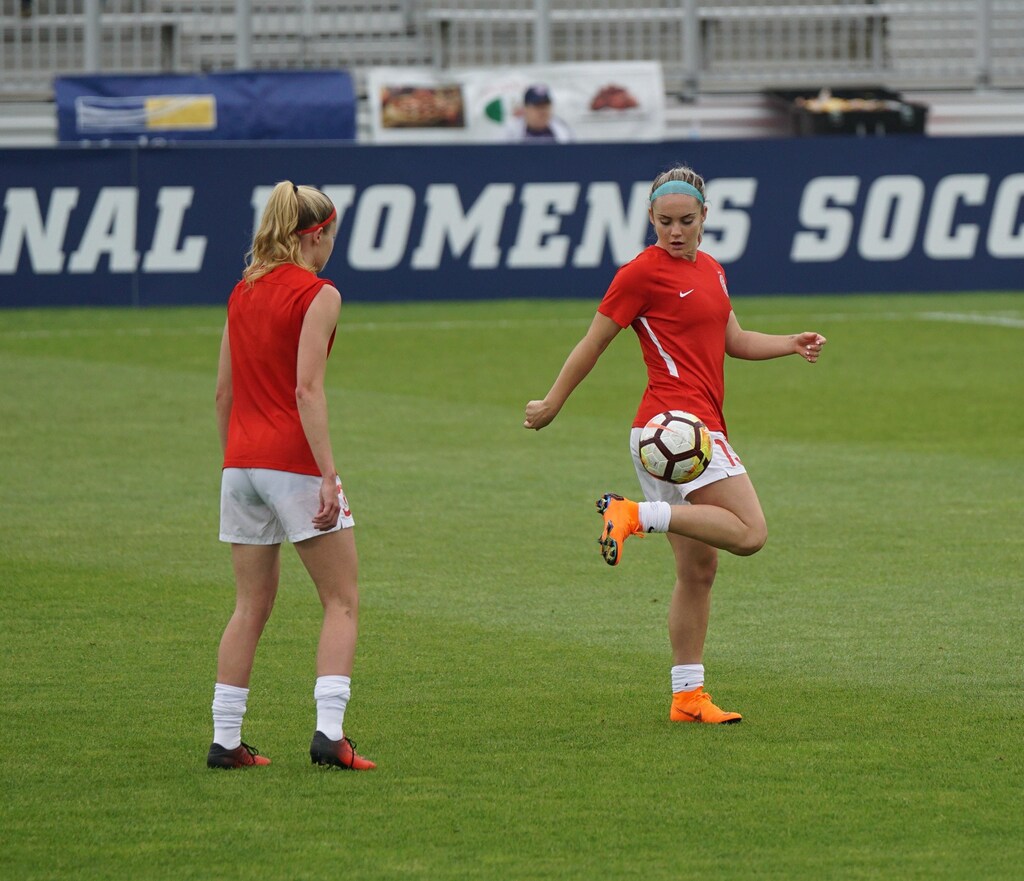 This image shows two women playing football, illustrating the power of sport to bring people together