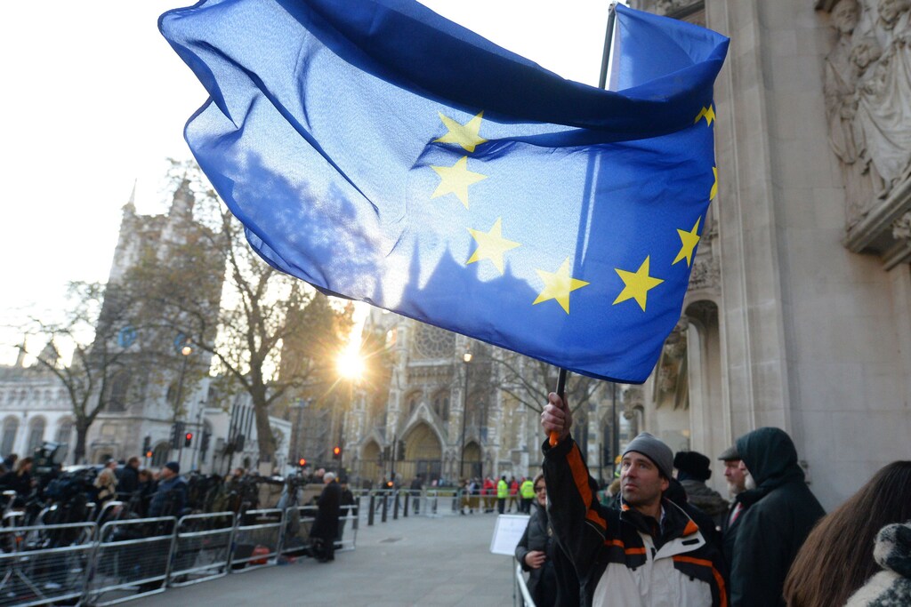 A man waiting to enter the public gallery waves a European Union flag outside the Supreme Court ahead of the challenge against a court ruling that Theresa May's government requires parliamentary approval to start the process of leaving the European Union, in Parliament Square, central London, Britain December 5, 2016. REUTERS/Victoria Jones/Pool - RTSUR4V