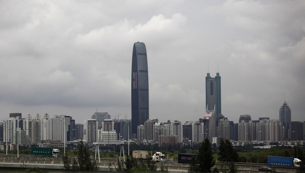 Container trucks cross a bridge in front of the 100-floor Kingkey 100, the tallest building in downtown Shenzhen neighboring Hong Kong, May 16, 2012. REUTERS/Bobby Yip (CHINA - Tags: BUSINESS) - GM1E85G1I1801