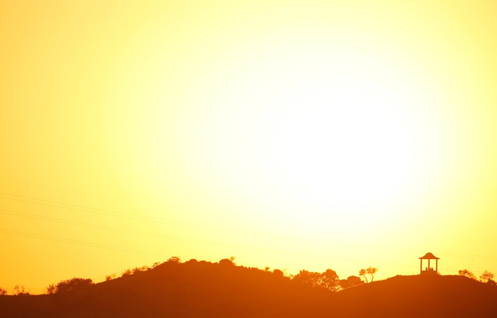 People are silhouetted against the setting sun at "El Mirador de la Alemana" (The viewpoint of the German), as the summer's second heatwave hits Spain, in Malaga, southern Spain July 24, 2019. REUTERS/Jon Nazca - RC1BDF35AB70