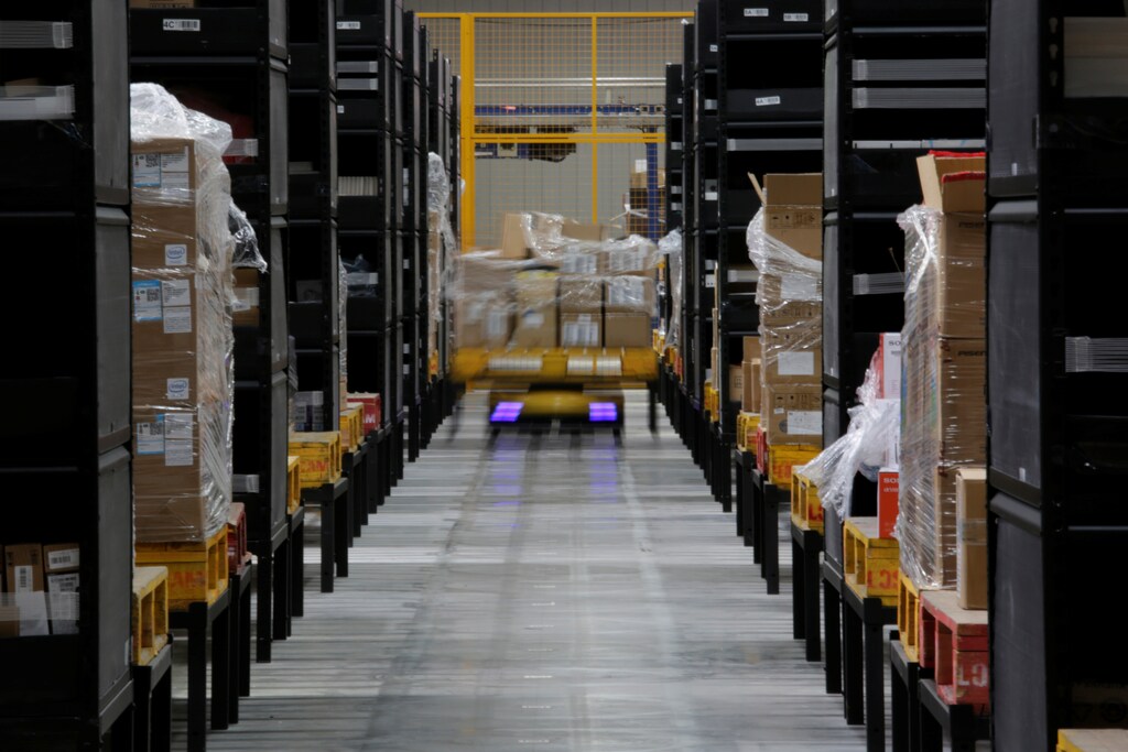 A robot moves goods through stocking shelves at a Suning automated guided vehicle (AGV) warehouse in Shanghai, China May 11, 2018. Picture taken May 11, 2018 with long exposure. REUTERS/Stringer