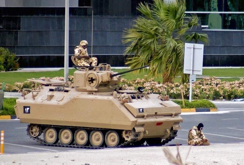 A soldier from the Gulf Cooperation Council (GCC) forces prays in front of his Armour Personnel Carrier as his fellow solider keeps watch while they guard the Bahrain Financial Harbour in Manama March 16, 2011. Bahraini forces used tanks and helicopters to drive protesters from the streets on Wednesday clearing a camp that had become a symbol of the Shi'ite Muslim uprising and drawing rare criticism from their U.S. Allies.