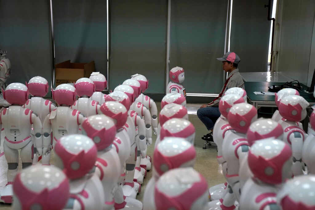 A worker puts finishing touches to an iPal social robot, designed by AvatarMind, at an assembly plant in Suzhou, Jiangsu province, China July 4, 2018. Designed to offer education, care and companionship to children and the elderly, the 3.5-feet tall humanoid robots come in two genders and can tell stories, take photos and deliver educational or promotional content. Picture taken July 4, 2018.REUTERS/Aly Song - RC12AA5524B0