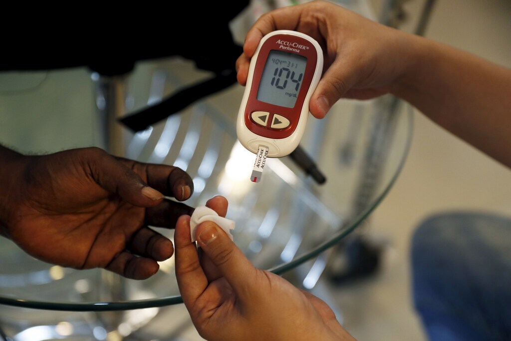 A paramedic (R) checks the blood sugar level of a patient at SS Diabetes Care clinic in Jakarta, Indonesia, April 22, 2016.
