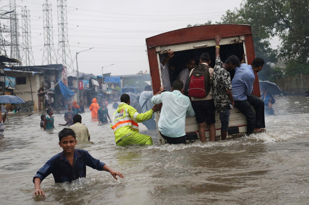 People ride on a truck on a flooded road after a heavy rainfall in Mumbai, India, September 4, 2019. REUTERS/Francis Mascarenhas TPX IMAGES OF THE DAY - RC1399630140