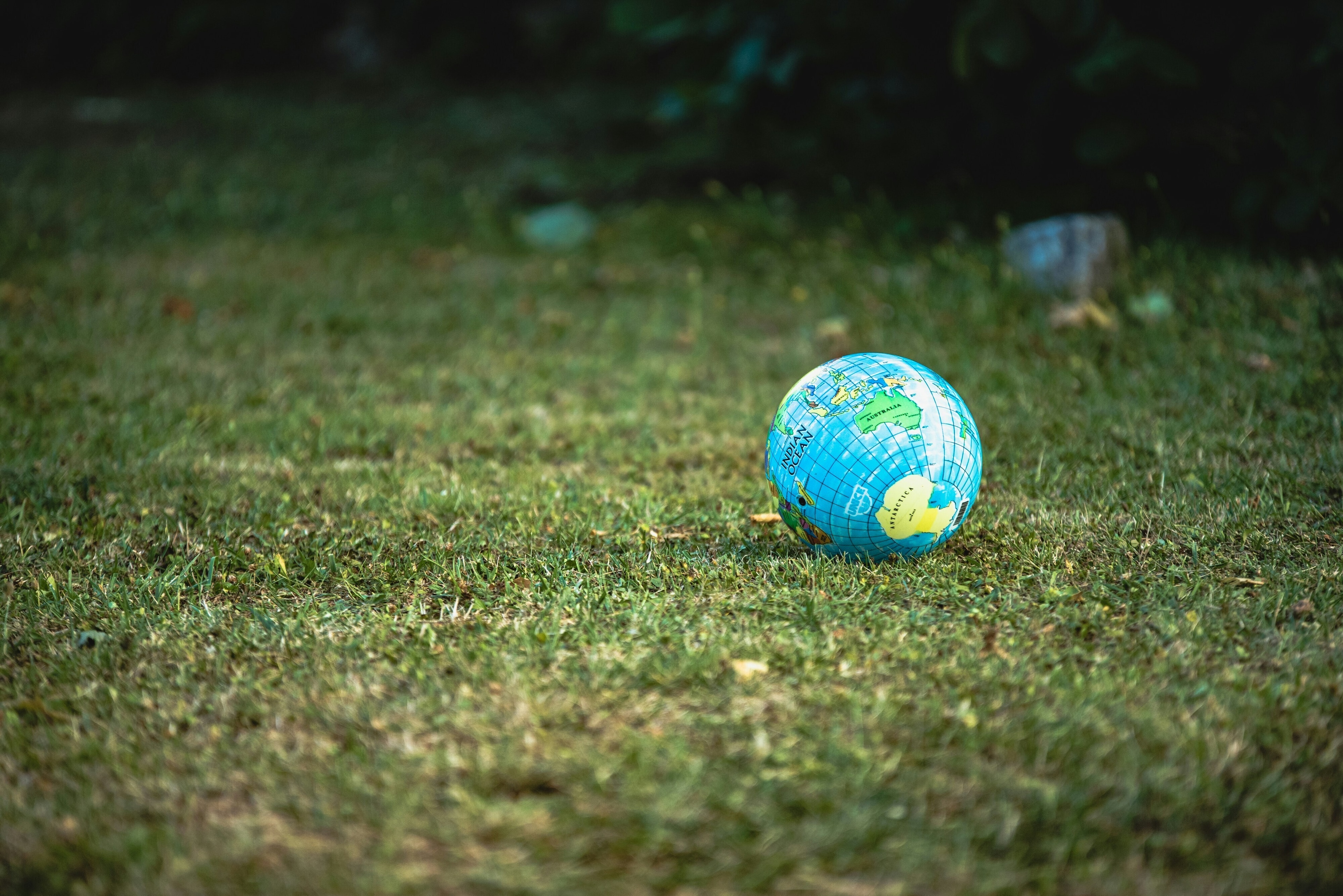 A beach ball of planet Earth on a field of grass, celebrating Earth Day