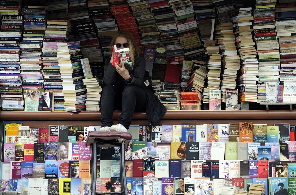 A woman reads a book at her open air book store in Skopje April 24, 2014. Macedonians will cast their ballots on Sunday April 27 in the second round of the presidential vote, overshadowed by the general elections. Macedonian voters look likely to hand conservative Prime Minister Nikola Gruevski a third term in a snap parliamentary election on Sunday, opting for relative economic stability and shrugging off opposition claims of creeping authoritarianism.