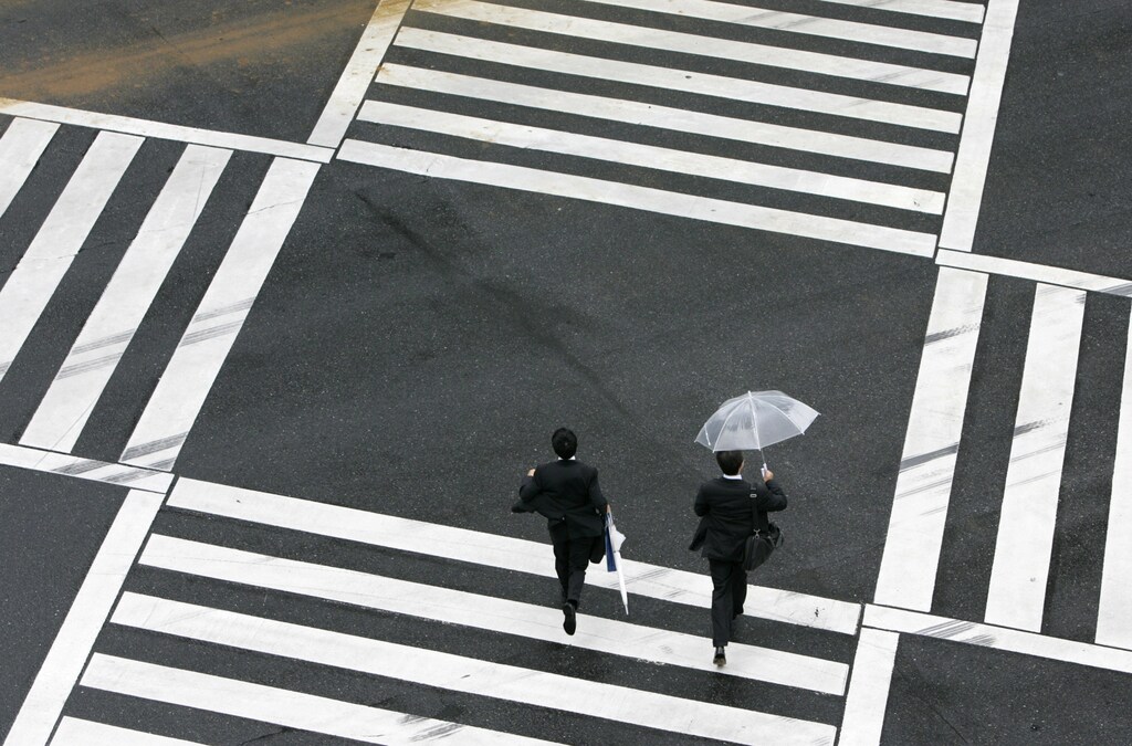 Businessmen walk across a street in Tokyo September 10, 2007. Japan's economy contracted more than expected in the second quarter, revised data showed on Monday, reinforcing views that the Bank of Japan is unlikely to raise interest rates next week amid a global credit squeeze and market fall-out. REUTERS/Yuriko Nakao (JAPAN) - GM1DWCTMVTAA