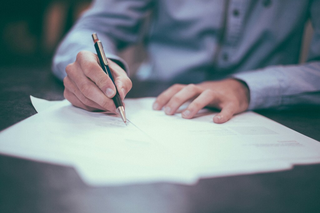 Man writing on legal paper.