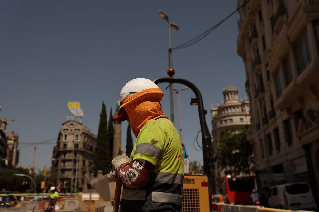 A worker is covered as he works on a street in Barcelona, while Europe is on red alert as heatwave brings health warning, Spain July 18, 2023.