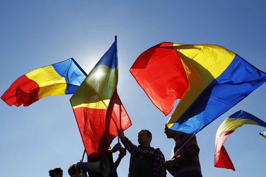 Trade unionists from the public transport sector wave national flags during a protest calling for an increase in wages, in front of Victoria palace, Romania's government headquarters, in Bucharest September 18, 2013. REUTERS/Bogdan Cristel (ROMANIA - Tags: TRANSPORT CIVIL UNREST BUSINESS EMPLOYMENT) - GM1E99I1MV401