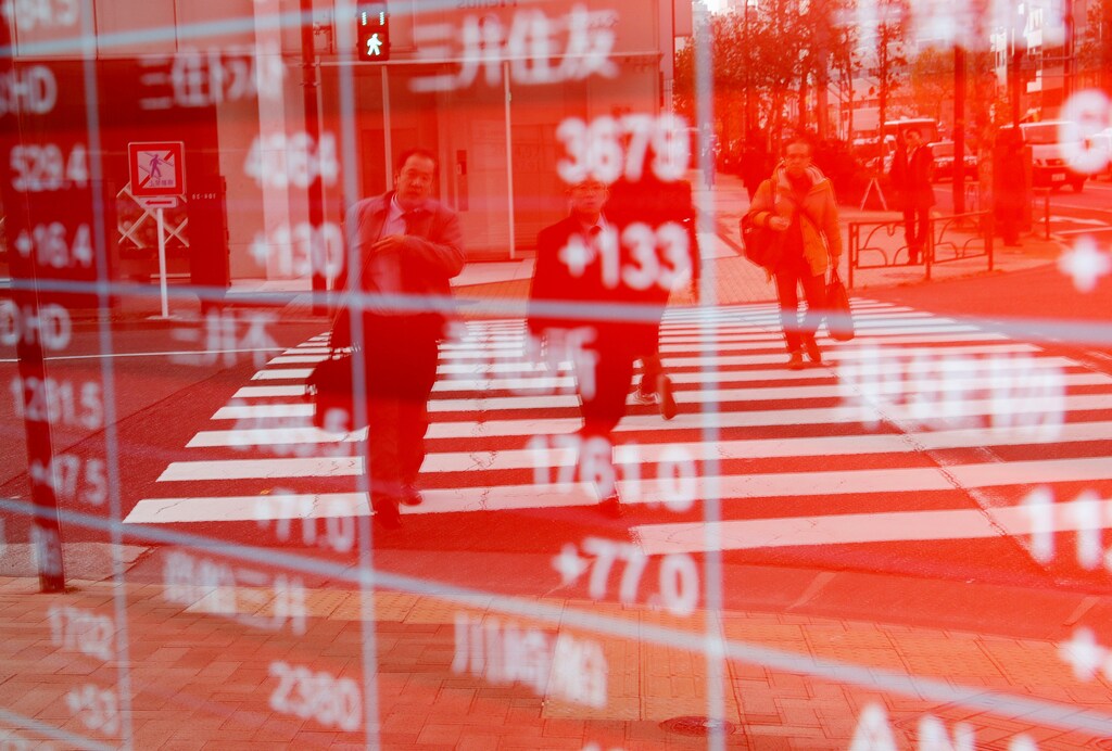 Pedestrians are reflected on an electronic board showing stock prices outside a brokerage in Tokyo, Japan December 27, 2018. REUTERS/Kim Kyung-Hoon - RC1449CDB900