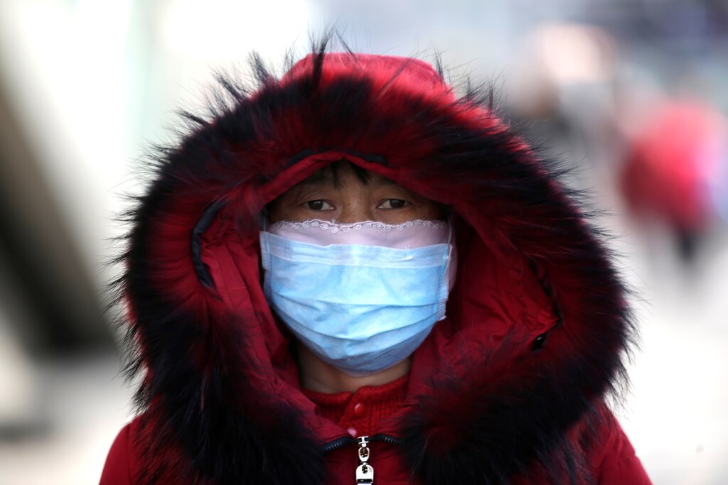 A woman wearing a mask is seen upon her arrival at Beijing West Railway Station in Beijing, China, as the country is hit by an outbreak of the new coronavirus, January 30, 2020. Picture taken January 30, 2020. REUTERS/Jason Lee - RC29SE9MADDC