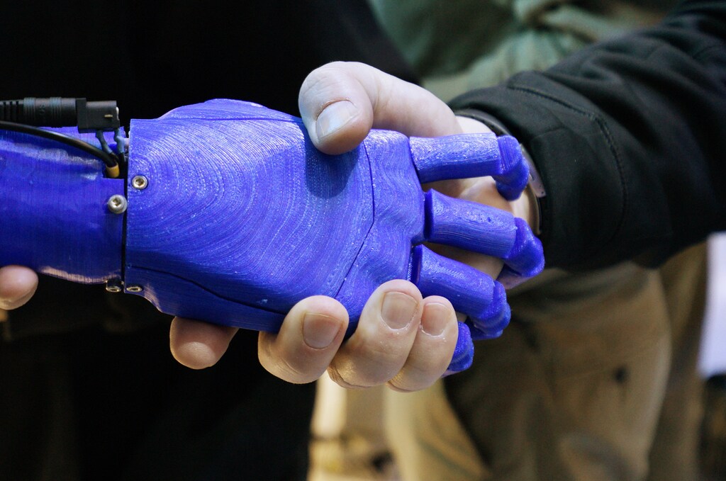 A man shakes hands with a robotic prosthetic hand in the Intel booth at the International Consumer Electronics show (CES) in Las Vegas, Nevada January 6, 2015. REUTERS/Rick Wilking (UNITED STATES - Tags: BUSINESS SCIENCE TECHNOLOGY) - RTR4KAY2