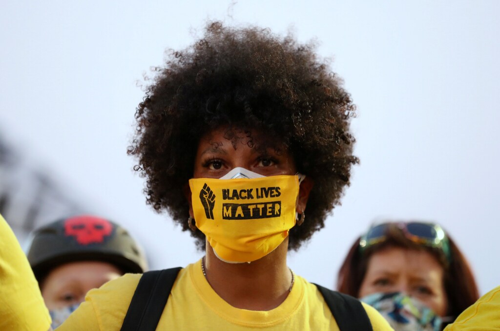 A protester with the "Black Lives Matter" slogan printed on her face mask joins a protest against racial inequality and police violence in Portland, Oregon, U.S., July 26, 2020. REUTERS/Caitlin Ochs - RC2G1I9IX7R4