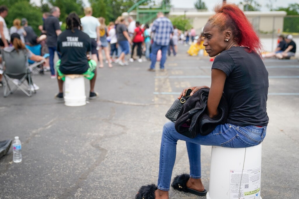Tin Reeves sits as she waits in a line outside a temporary unemployment office established by the Kentucky Labor Cabinet at the State Capitol Annex in Frankfort, Kentucky, U.S. June 17, 2020. REUTERS/Bryan Woolston - RC27BH9G71LZ
