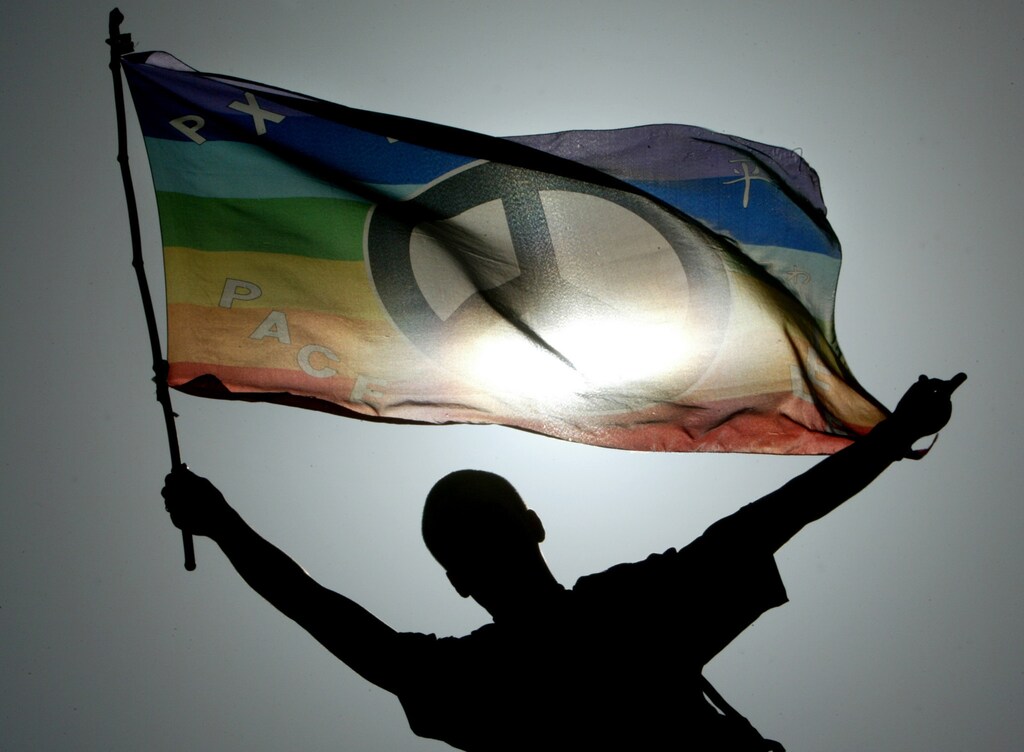 An unidentified peace activist waves his flag with a peace symbol during ademonstration in Hamburg April 21, 2003. Some 2,000 marched to protest forpeace and against war. NO RIGHTS CLEARANCES OR PERMISSIONS ARE REQUIRED FOR THIS IMAGE REUTERS/Christian Charisius CHA/JOHGERMANY - RP3DRIHQRCAA