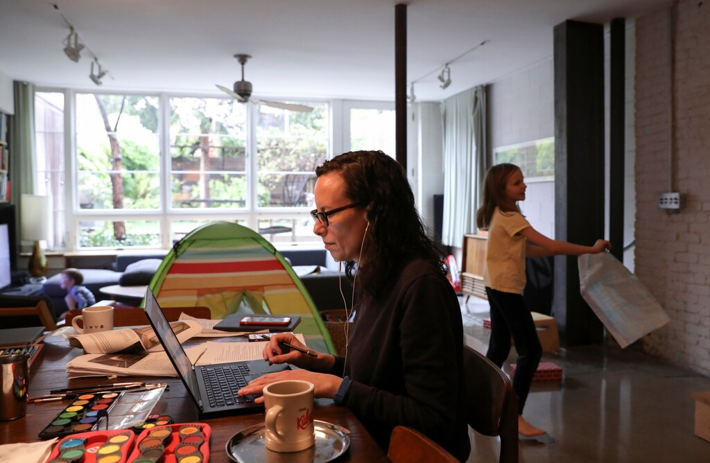 Naomi Hassebroek works from home surrounded by art supplies her daughter needs for a school project during the outbreak of the coronavirus disease (COVID-19) in Brooklyn, New York City, New York, U.S., April 24, 2020. REUTERS/Caitlin Ochs - RC2BBG9JN83Z