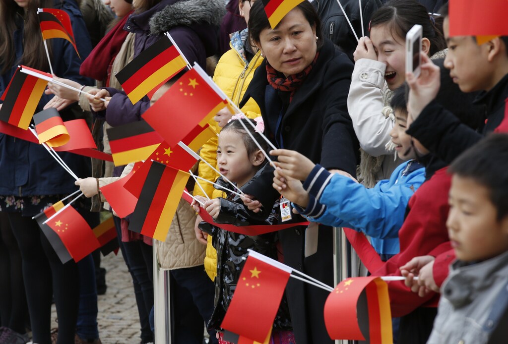 Well wishers wave German and Chinese flags as they await the arrival of China's President Xi Jinping and his wife Liyuan at Bellevue presidential palace in Berlin March 28, 2014. REUTERS/Fabrizio Bensch (GERMANY - Tags: POLITICS) - LR1EA3S0SAJVA
