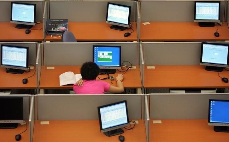 A trader plays a computer game in the trading room of the Shanghai Petroleum Exchange in Shanghai August 18, 2006. The new Shanghai Petroleum Exchange was launched with the sound of a gong on Friday, but traders said the market's success could hinge on whether China allows more price flexibility. REUTERS/Aly Song (CHINA)