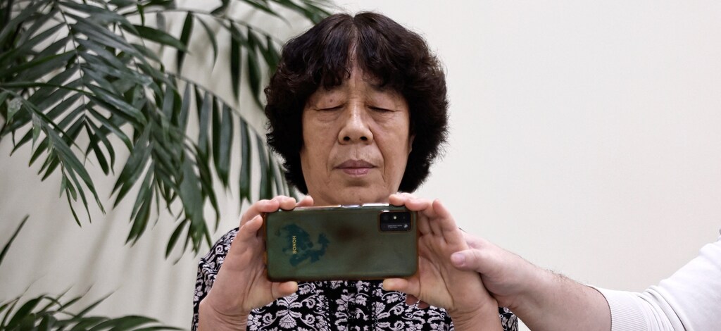 A teacher instructs an elderly woman during a smartphone photography class. Vision loss disproportionately affects people in the Asia Pacific — but it is often preventable.
