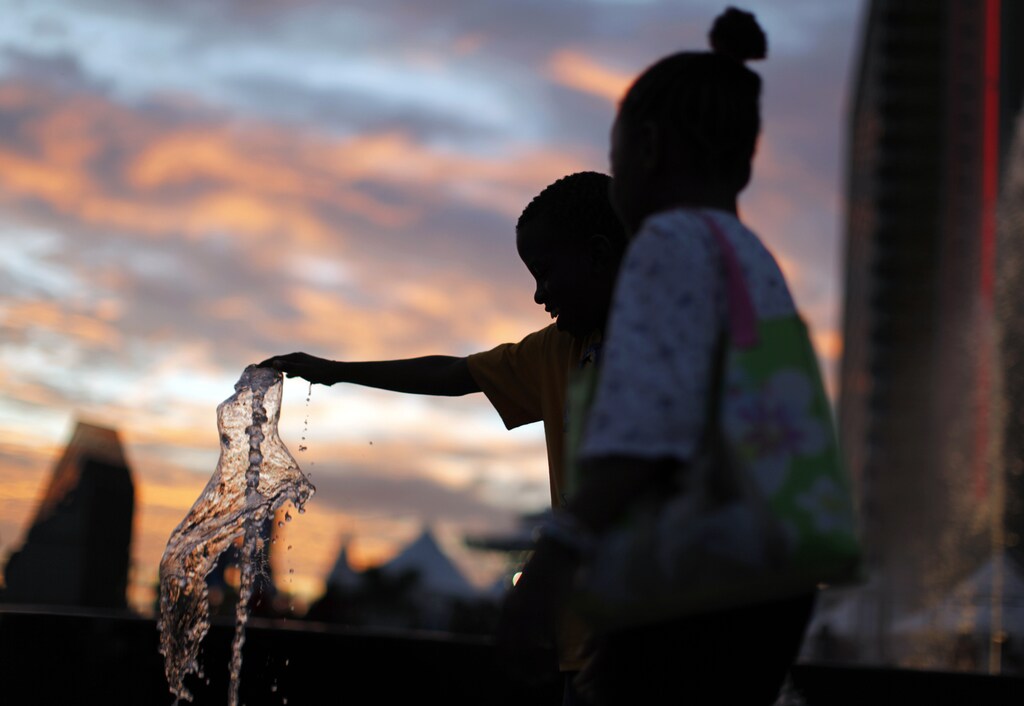 A Trinidadian girl plays in a water fountain.