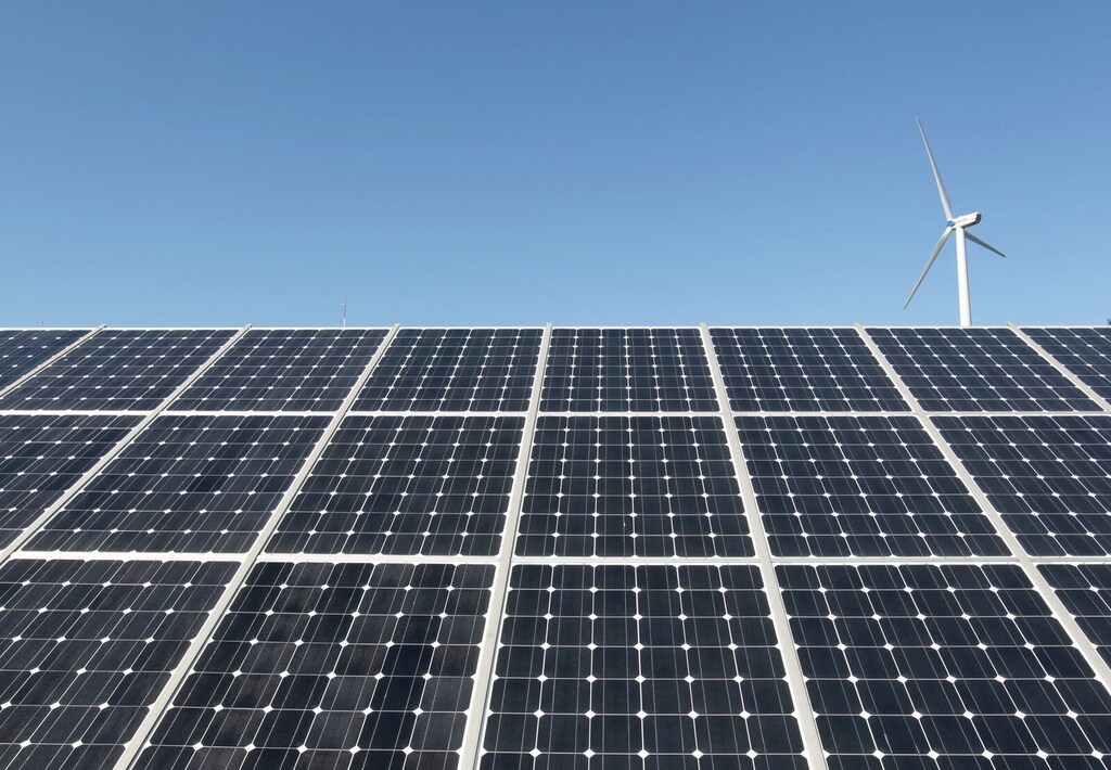 Una turbina eólica sobre paneles de una planta de energía solar de Korea South East Power Co. en Incheon, a unos 90 km al oeste de Seúl, Corea del Sur.