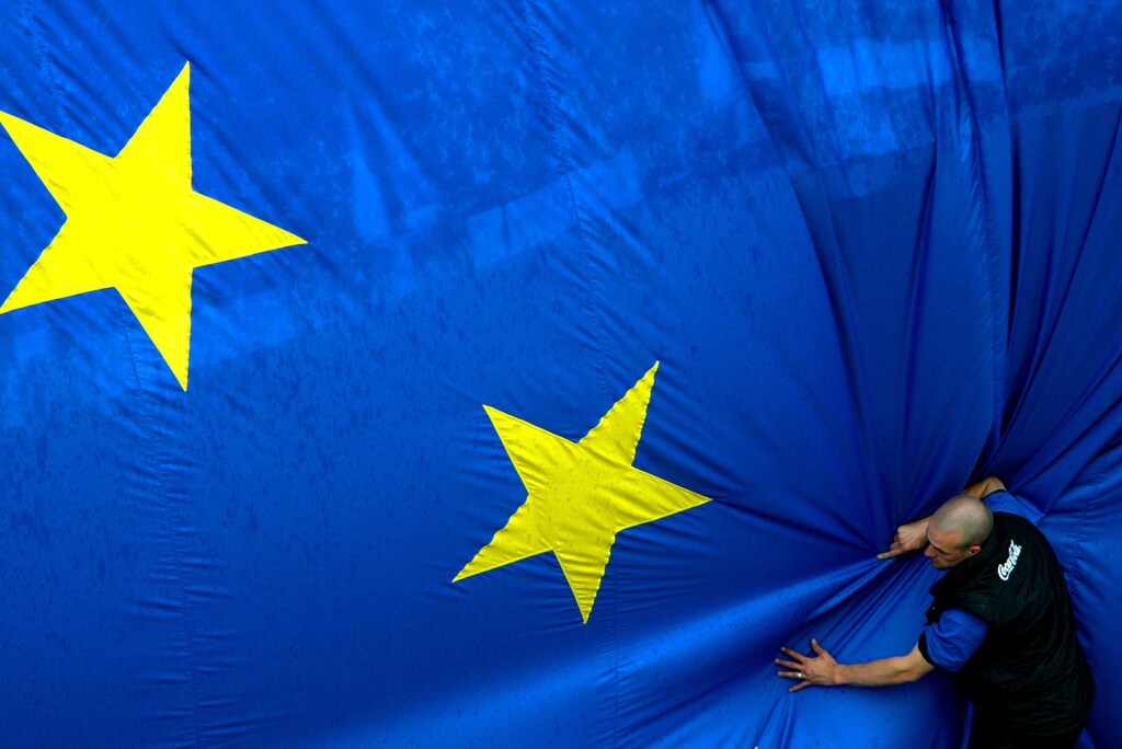 A worker adjusts a 150 metre-square European flag during a celebration in Brussels' Jubilee Park to mark the expansion of the European Union to 25 from 15 states on April 30, 2004. Cyprus, the Czech Republic, Estonia, Hungary, Latvia, Lithuania, Malta, Poland, Slovakia and Slovenia will join the European Union on May 1. UNICS REUTERS/Francois Lenoir Pictures of the Year 2004 FLR/CRB - RP4DRIGNBSAB